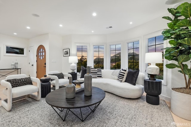 living room featuring arched walkways, visible vents, and recessed lighting