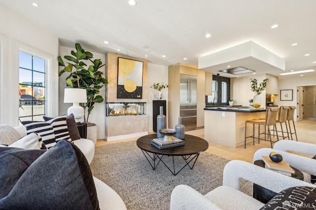 living area featuring recessed lighting and a multi sided fireplace