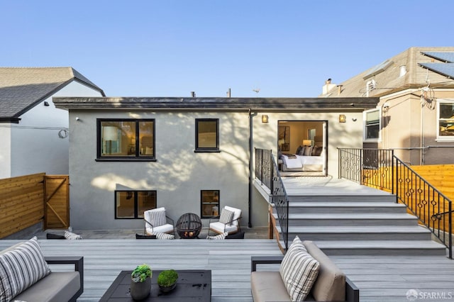 back of house with stairway, an outdoor hangout area, fence, a wooden deck, and stucco siding