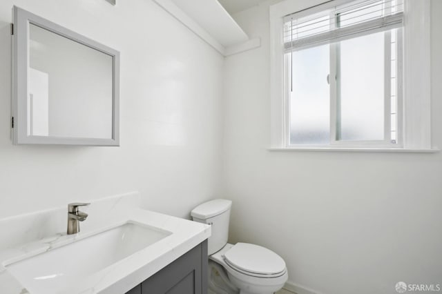 half bath with plenty of natural light, toilet, and vanity