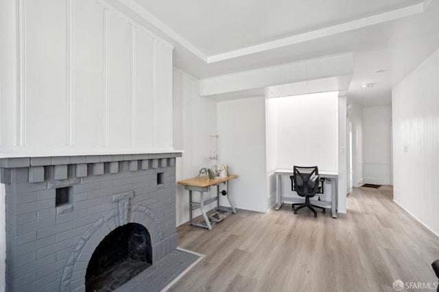 living room with light wood-style floors, baseboards, and a fireplace