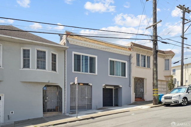 view of front of property with stucco siding and fence