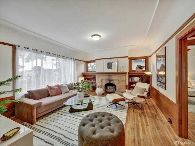 living room featuring wooden walls, a fireplace, and light wood-type flooring