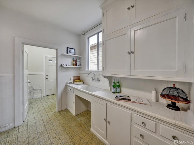 kitchen featuring white cabinetry and sink