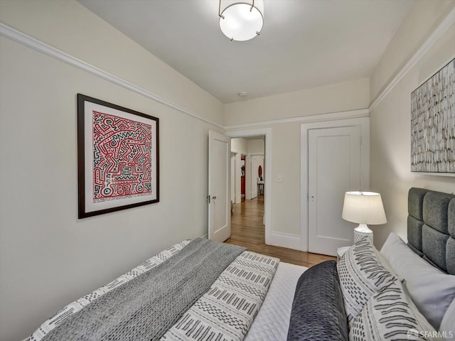 bedroom with light hardwood / wood-style floors and a closet