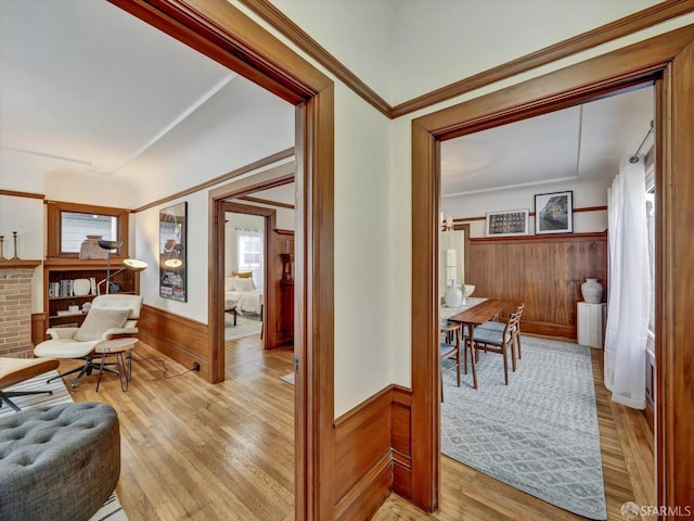 hallway with light hardwood / wood-style floors and wood walls