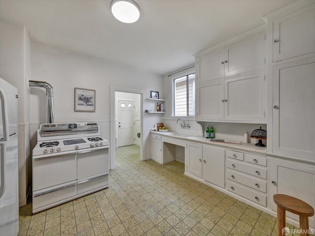 kitchen with white cabinetry, white appliances, and sink