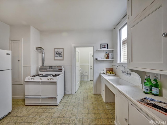 kitchen featuring white cabinetry, sink, white appliances, and tile walls