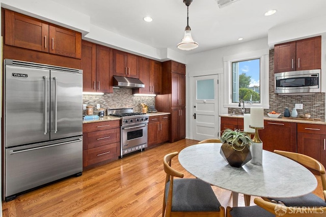221 Noe St Unit 12, San Francisco, CA 94114 - kitchen featuring built in appliances, extractor fan, tasteful backsplash, light countertops, and recessed lighting