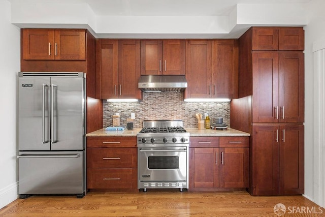 221 Noe St Unit 12, San Francisco, CA 94114 - kitchen featuring high end appliances, ventilation hood, tasteful backsplash, light stone countertops, and light wood-style flooring