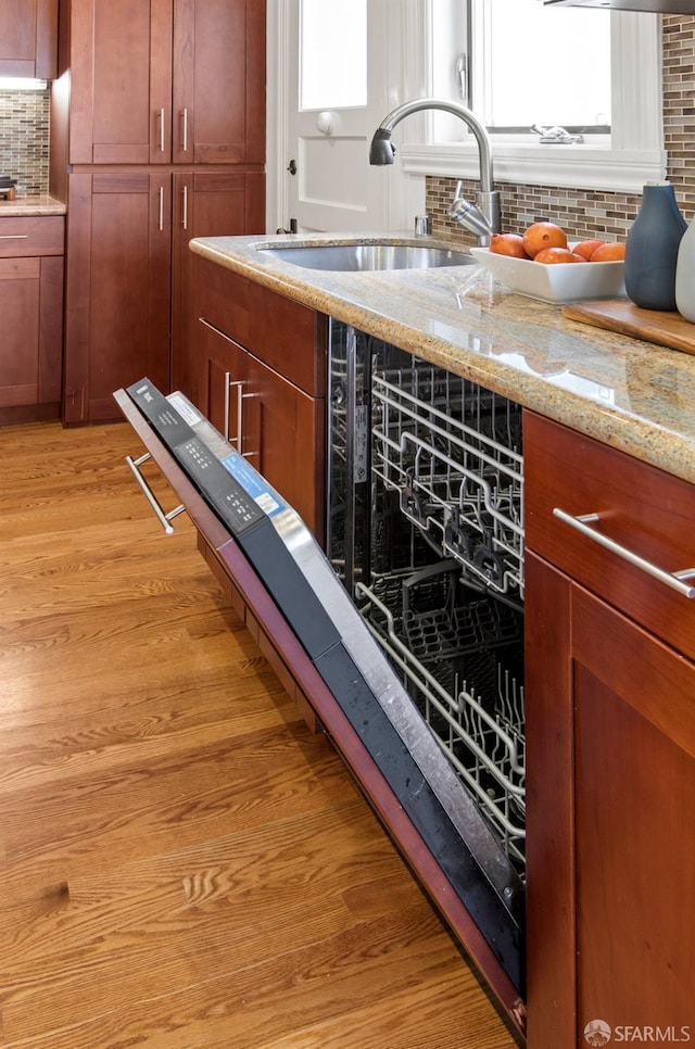 221 Noe St Unit 12, San Francisco, CA 94114 - kitchen featuring tasteful backsplash, light wood-type flooring, light stone countertops, and brown cabinetry