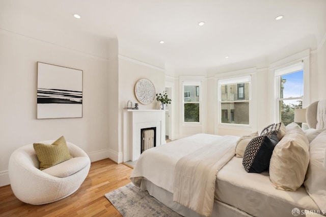 bedroom with crown molding and light hardwood / wood-style flooring