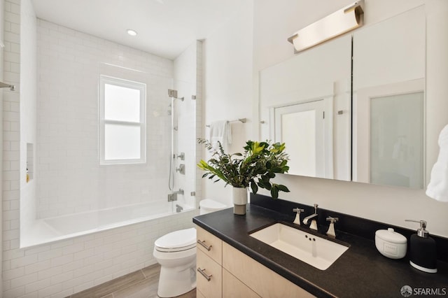 full bathroom with toilet, vanity, and tiled shower / bath