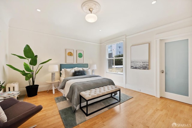 bedroom with light hardwood / wood-style floors, radiator, and crown molding