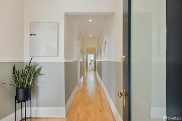 hall with light hardwood / wood-style flooring and ornamental molding