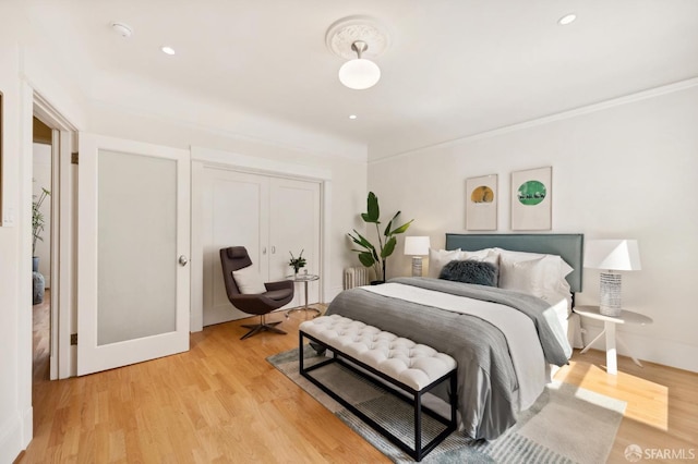 bedroom featuring light hardwood / wood-style floors and radiator heating unit