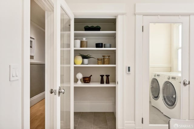 clothes washing area featuring tile patterned floors and washer and dryer