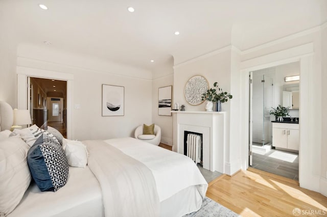 bedroom featuring light wood-type flooring and ensuite bathroom