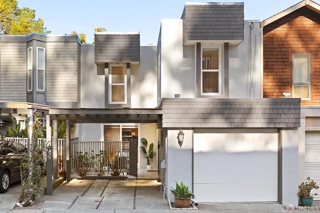 view of front of property with stucco siding, a garage, and driveway