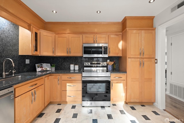 kitchen with decorative backsplash, visible vents, appliances with stainless steel finishes, and a sink