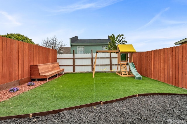 view of yard with a fenced backyard and a playground