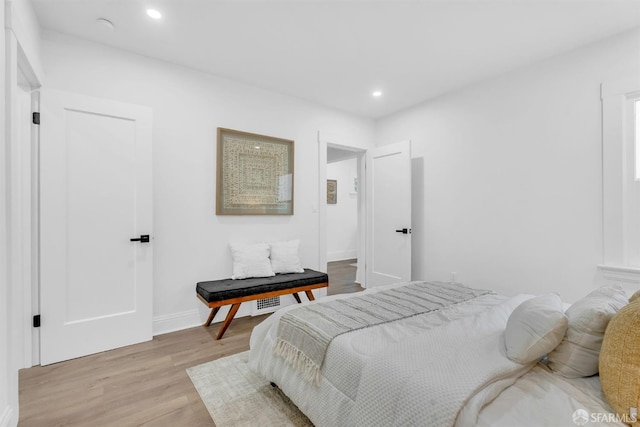 bedroom featuring baseboards, wood finished floors, and recessed lighting