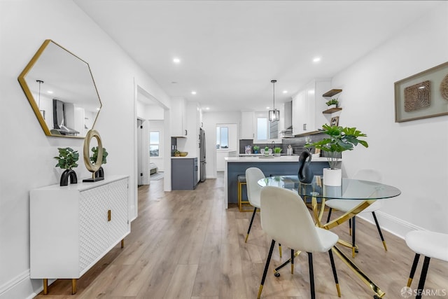 dining area featuring light wood-type flooring, baseboards, and recessed lighting