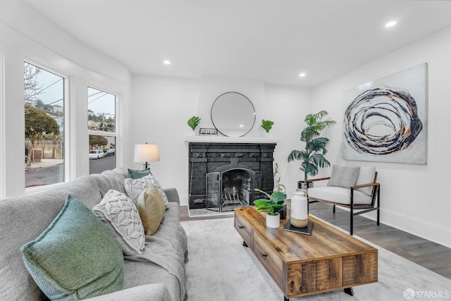 living room with baseboards, a fireplace, wood finished floors, and recessed lighting