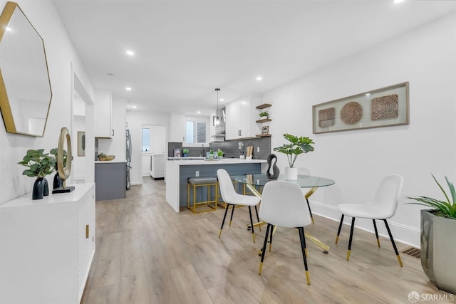 dining room featuring recessed lighting, baseboards, visible vents, and light wood finished floors