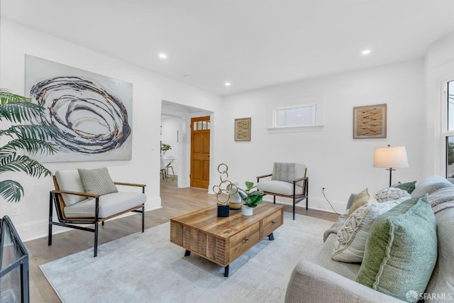 living area with baseboards, light wood-style flooring, and recessed lighting