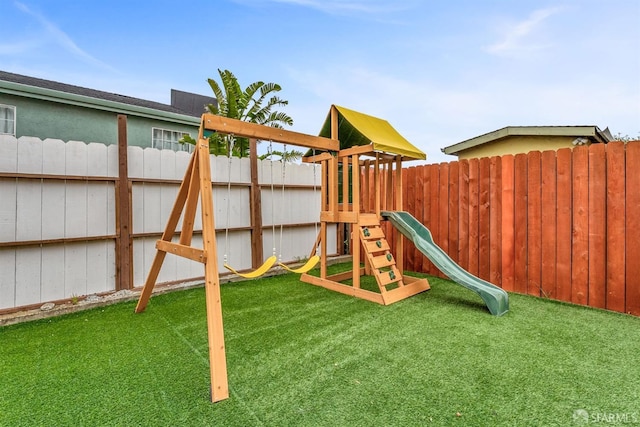 view of playground with a yard and fence