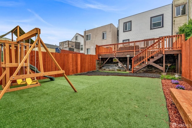 view of yard with stairs, a playground, fence, and a wooden deck