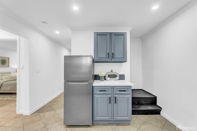 kitchen featuring baseboards, light tile patterned flooring, freestanding refrigerator, and recessed lighting