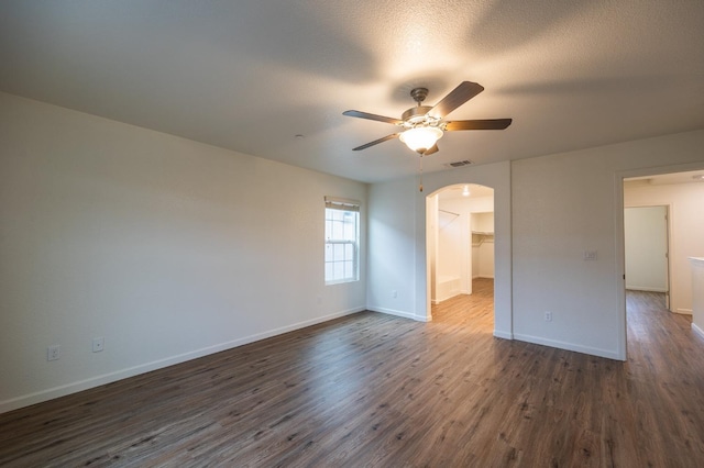 unfurnished room featuring ceiling fan, dark hardwood / wood-style flooring, and a textured ceiling