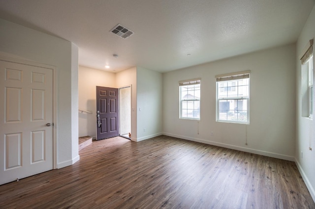 unfurnished bedroom featuring dark wood-type flooring and a textured ceiling