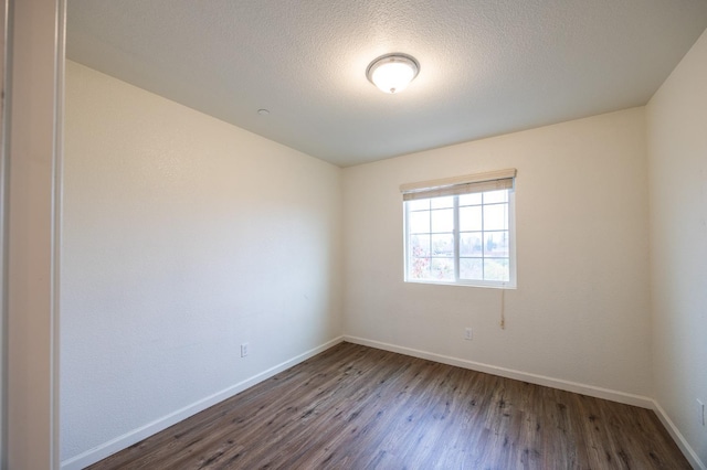 spare room with dark hardwood / wood-style flooring and a textured ceiling