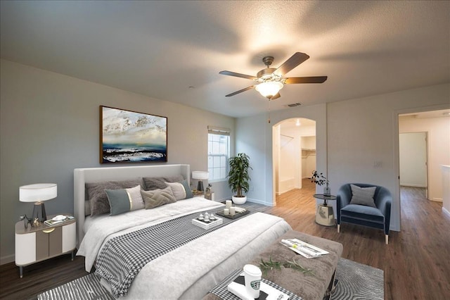 bedroom featuring hardwood / wood-style floors, ceiling fan, and a spacious closet