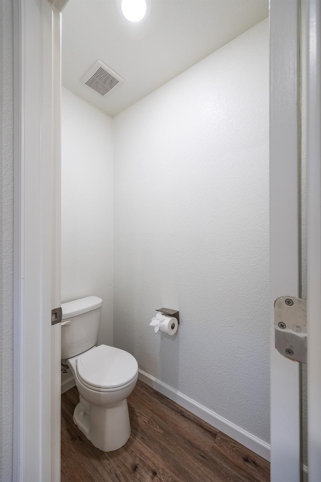 bathroom with hardwood / wood-style floors and toilet