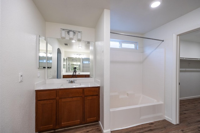 bathroom featuring hardwood / wood-style floors, vanity, and shower / bathtub combination