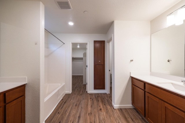 bathroom with hardwood / wood-style floors, vanity, and  shower combination