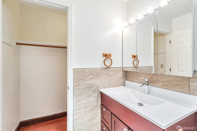 bathroom featuring tile walls, vanity, and wood finished floors