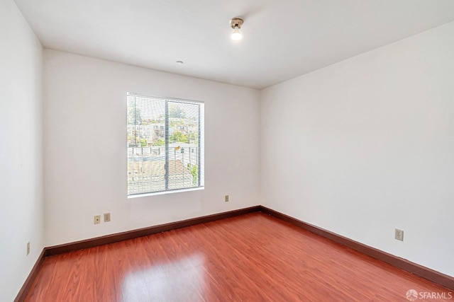 unfurnished room featuring wood finished floors and baseboards
