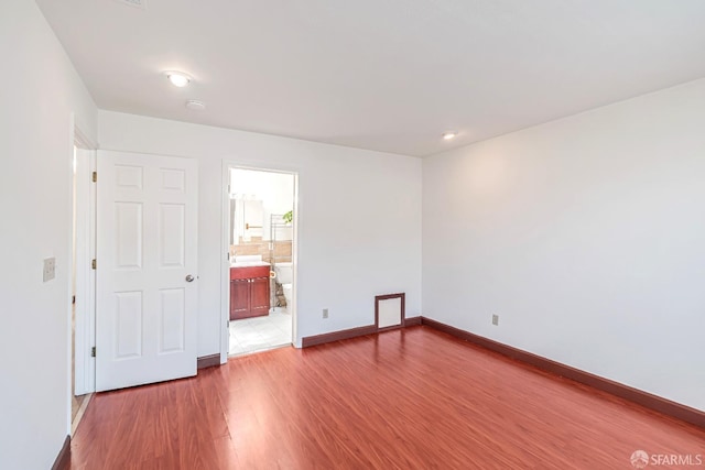unfurnished room with wood finished floors and baseboards