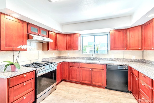 kitchen featuring dishwasher, stainless steel range with gas cooktop, a sink, under cabinet range hood, and light stone counters