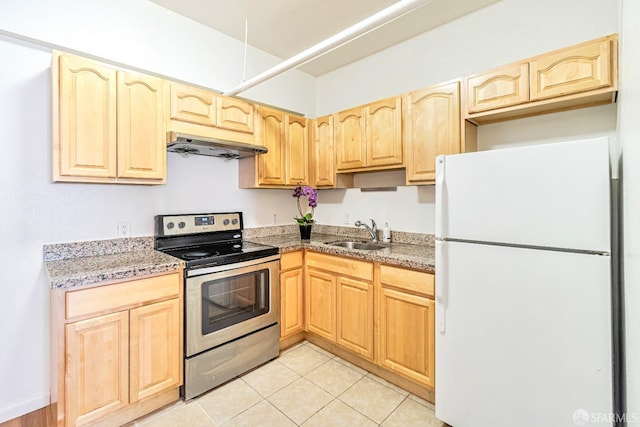 kitchen featuring freestanding refrigerator, stainless steel electric range oven, under cabinet range hood, a sink, and light brown cabinets