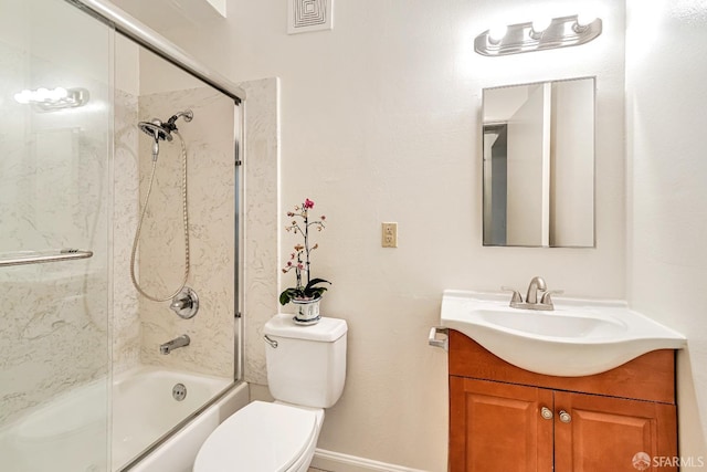 bathroom featuring toilet, vanity, combined bath / shower with glass door, and baseboards
