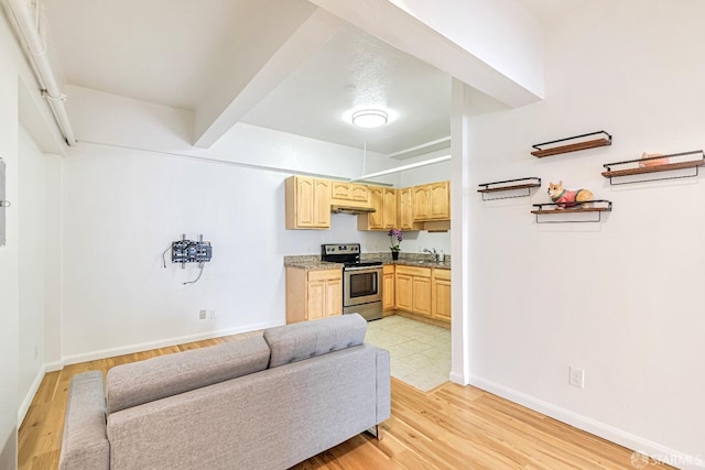 kitchen with stainless steel electric stove, light brown cabinets, light wood-type flooring, baseboards, and beamed ceiling