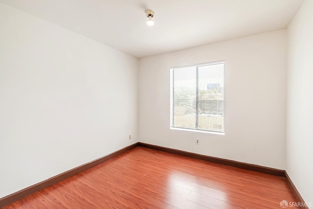 spare room with wood finished floors and baseboards