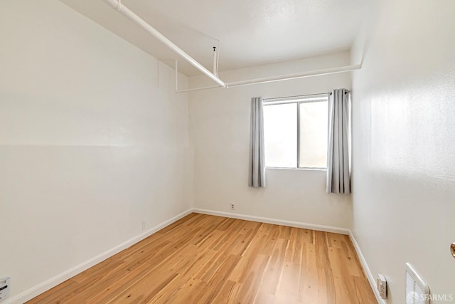 empty room featuring light wood finished floors and baseboards