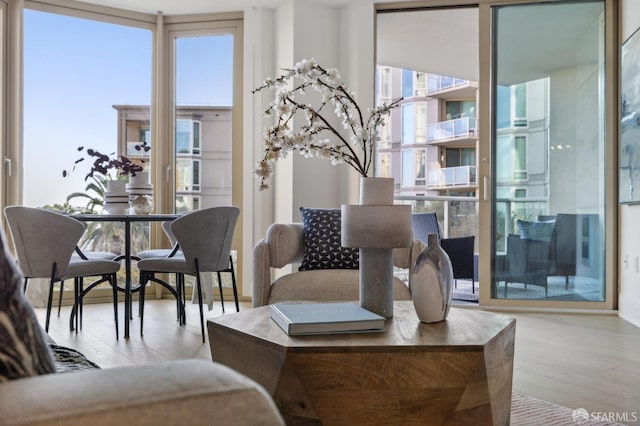 living room featuring light wood-type flooring and floor to ceiling windows